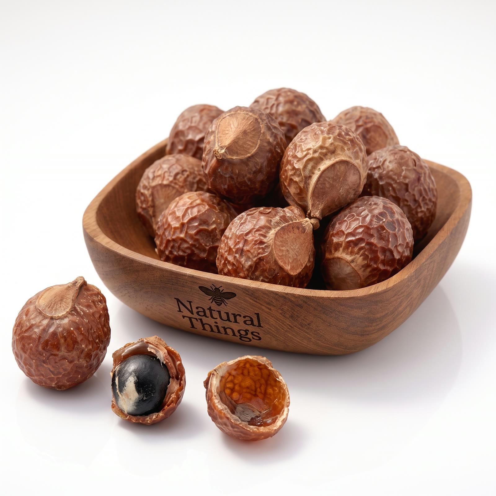 Deshelled soap nuts, whole and split open, in a wooden bowl